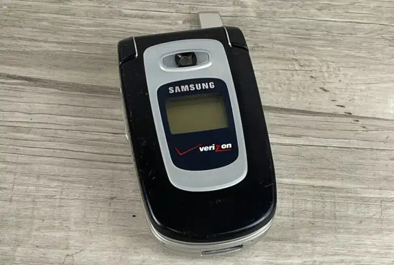 old samsung flip phone, wooden table background